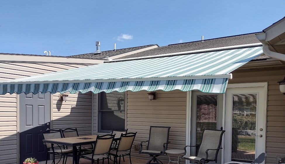 Close up of a white fabric awning with green stripes.