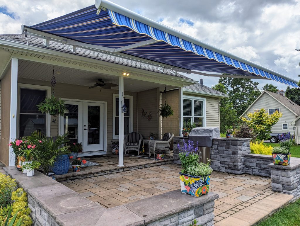 outdoor kitchen patio under a blue retractable awning