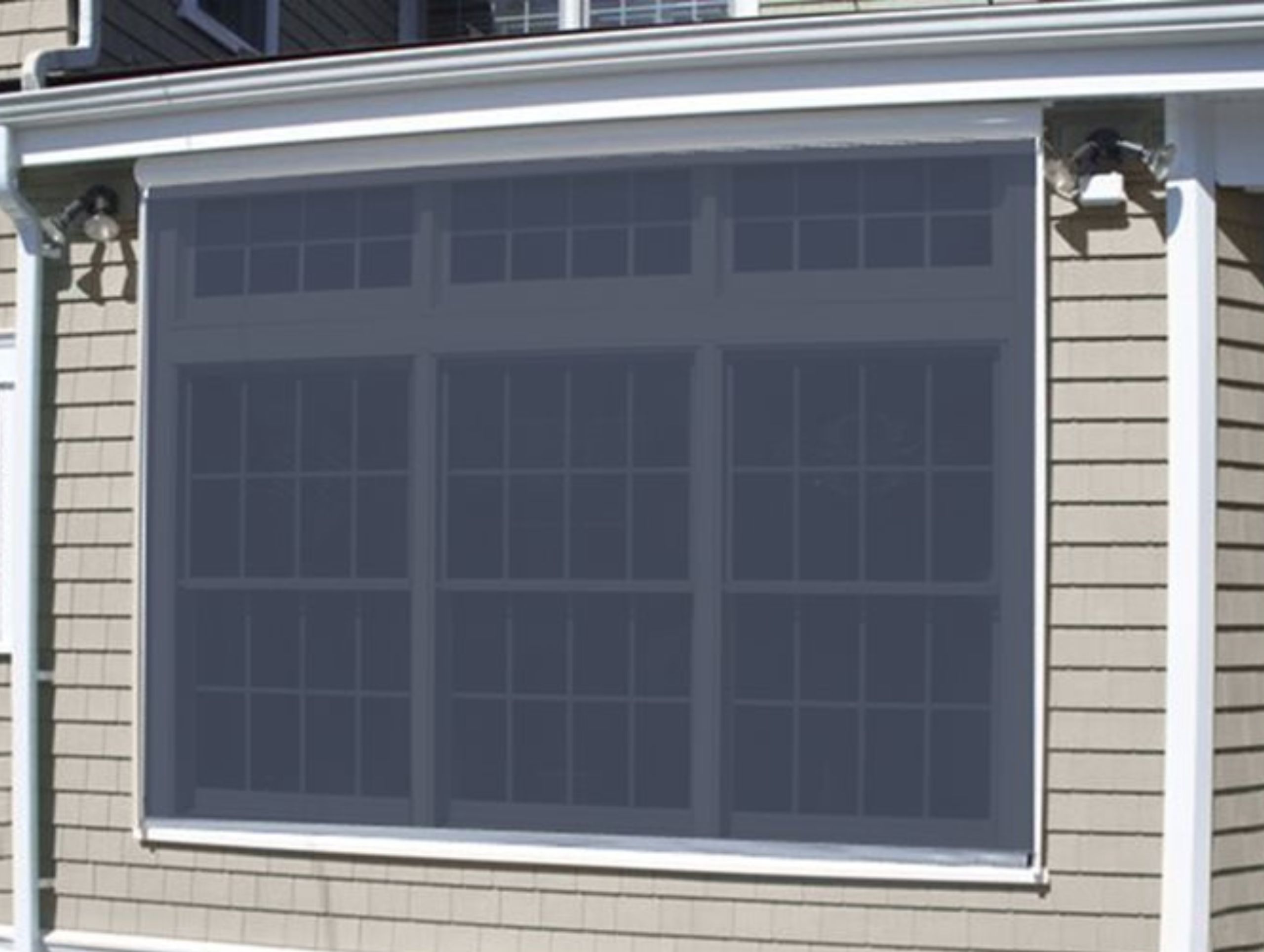 Close up of a window covered by an exterior solar screen.
