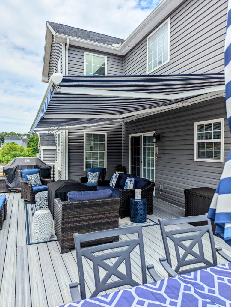 blue and white striped awning over a deck, protecting furniture underneath